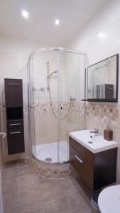 y baño con ducha y lavamanos. en Elegant & Stylish Center Apartments!, en Praga