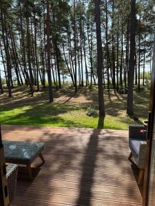 a porch with a table and a bench and trees at Valgeranna puhkekeskuse hotell in Valgeranna