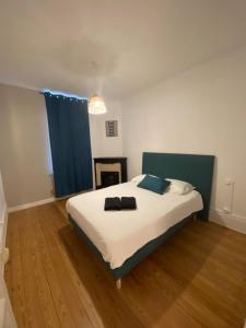 1 dormitorio con 1 cama grande y cortina azul en Le bon coin en Le Creusot