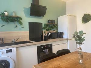 a kitchen with a counter with a sink and a table at Le bon coin in Le Creusot