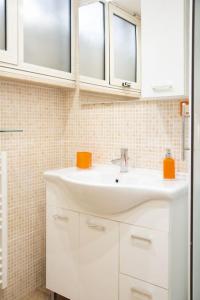 baño con lavabo blanco y 2 ventanas en Locazione Turistica- Maxxi loft, en Roma