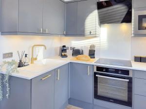 a kitchen with blue cabinets and a sink at Harrogate House Apt 4 - Cheltenham Parade Loft in Harrogate