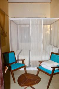 Habitación con 2 sillas y ventana en The Island Stone Town hotel en Ngambo