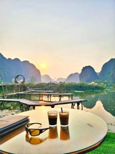 two cups of coffee on a table with mountains in the background at For You Homestay in Ninh Binh
