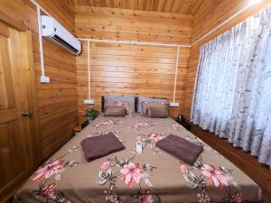 En eller flere senge i et værelse på The Elegance Wooden Villa