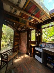 eine Küche mit einem Herd und einer Bank in einem Zimmer in der Unterkunft Casa Barco Campeche in Florianópolis