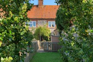 a house with a gate and a fence at Goose Cottage by Big Skies Cottages in Titchwell