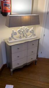 a white dresser with a lamp on top of it at Hostal Docar in Lerma