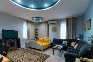 a living room with a couch and a tv at Luxury Studio for 3 persons, near Carevec, Veliko Tarnovo in Veliko Tŭrnovo
