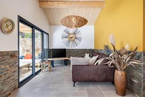 ein Wohnzimmer mit Sofa und Fernseher in der Unterkunft La Cabane du Huga N°3 in Lacanau