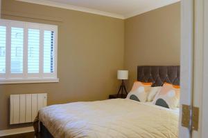 a bedroom with a large bed and a window at Seaside Apartment in Largs