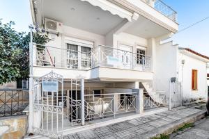 a white house with balconies and a staircase at Sotiria House in Preveza