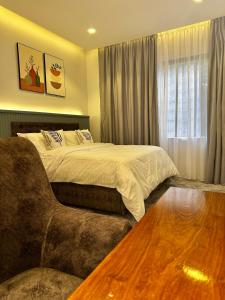 a bedroom with a large bed and a couch at CozyHome 75”TV, 5mints from the Beach & City in Dar es Salaam +15 photos