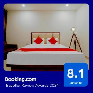 a bedroom with a large bed with red pillows at Hotel Golfview in Panchkula