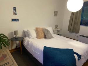 1 dormitorio con cama blanca y mesa en Ocean Retreat en Brighton