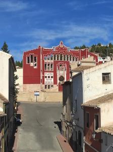 un gran edificio rojo en medio de una ciudad en Casa para relajarse, con vistas., en Caravaca de la Cruz