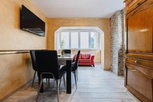 - une salle à manger avec une table, des chaises et un canapé rouge dans l'établissement Noua Oasis Bnb-perfect For Groups, à Timișu de Jos