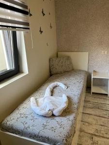 un letto con un asciugamano bianco di Casa Ana a Constanţa