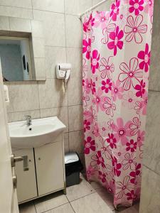 un bagno con lavandino e tenda doccia con fiori di Casa Ana a Constanţa