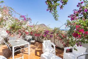 a patio with a table and chairs and flowers at Ocean House in Granadilla de Abona