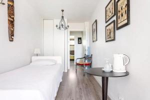a white bedroom with a bed and a table at Ocean House in Granadilla de Abona