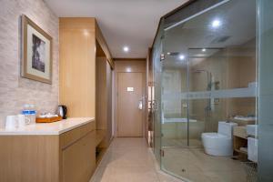 a bathroom with a glass shower and a toilet at Xiamen Shuyue Hotel in Xiamen