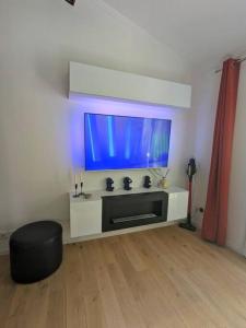 a living room with a large flat screen tv at Maison individuelle avec jardin ensoleillé in Auribeau-sur-Siagne