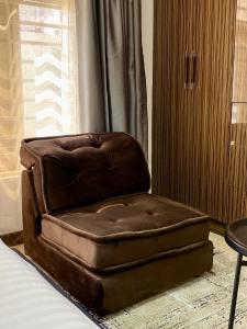 una silla de cuero marrón sobre una cama en GLOVIS LUXURY APARTMENT, en Abuja