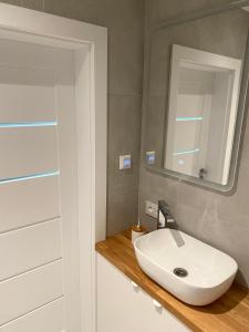 a bathroom with a white sink and a mirror at Apartament Otwarta Wrocław in Wrocław