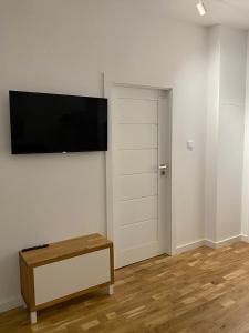 a room with a flat screen tv on a wall at Apartament Otwarta Wrocław in Wrocław