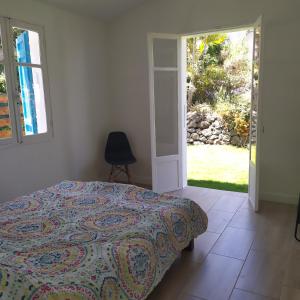una camera con un letto e una sedia e una finestra di Gîte Timadam a Cilaos