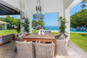 a dining room with a table and chairs and a chandelier at LXR Villa with breathtaking views to the Mediterranean 4 HAB in Torremuelle