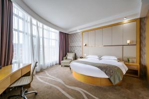 a hotel room with a large bed and a desk at Xiamen Shuyue Hotel in Xiamen