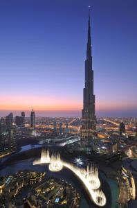 a large clock tower towering over a city at night at Armani Hotel Dubai in Dubai