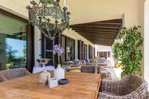 a dining room with a table and chairs and a chandelier at LXR Villa with breathtaking views to the Mediterranean 4 HAB in Torremuelle