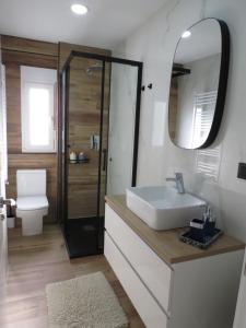 y baño con lavabo, aseo y espejo. en Apartamento AIRES DEL NORTE, con WiFi gratis en Santander