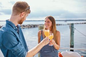 Egernsund的住宿－Hausboot WELL - Husbåd WELL，一位男人和女人拿着香槟杯