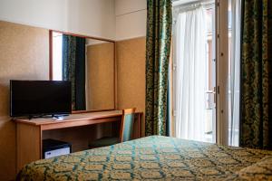 a hotel room with a bed and a desk with a television at Hotel Mary in Vicenza