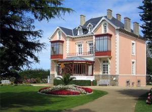 a large pink house with a garden in front of it at Granville : appart. vue mer proche centre ville in Granville