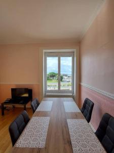 a room with a large table and a large window at Granville : appart. vue mer proche centre ville in Granville