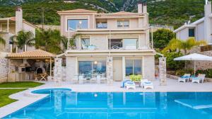 a villa with a swimming pool and a house at Infinite Blue Epidavros in Ancient Epidauros