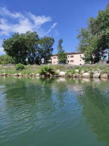 une masse d'eau avec un bâtiment en arrière-plan dans l'établissement Studio 314 - LES SUITES DE ROBINSON - Résidence avec piscine en bord de Siagne, à Mandelieu-La-Napoule, à Mandelieu-la-Napoule