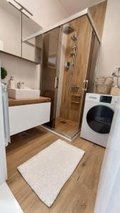 a bathroom with a sink and a washing machine at MINA modern & cozy apartment main city square GTC Skopje in Skopje