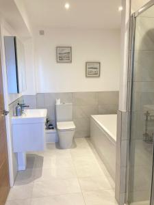 a bathroom with a toilet and a sink and a bath tub at Superb 3 Bed House Close To Snowdonia in Llansantffraid Glan Conwy