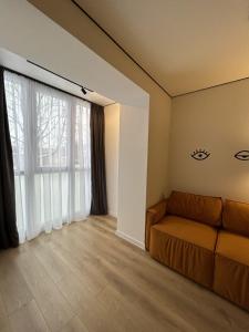 a living room with a couch and a large window at Fancy appartment in Poltava +20 photos