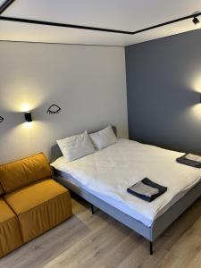 a small bedroom with a bed and a couch at Fancy appartment in Poltava