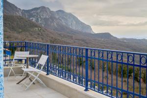 a blue railing with two chairs and a table on a balcony at Sunbreeze Delux Vilas in Budva