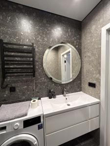 a bathroom with a sink and a washing machine at Fancy appartment in Poltava