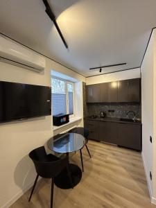 a kitchen with a glass table and black chairs at Fancy appartment in Poltava