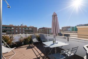a patio with a table and an umbrella on a roof at Feelathome Waldorf Suites Apartments in Madrid